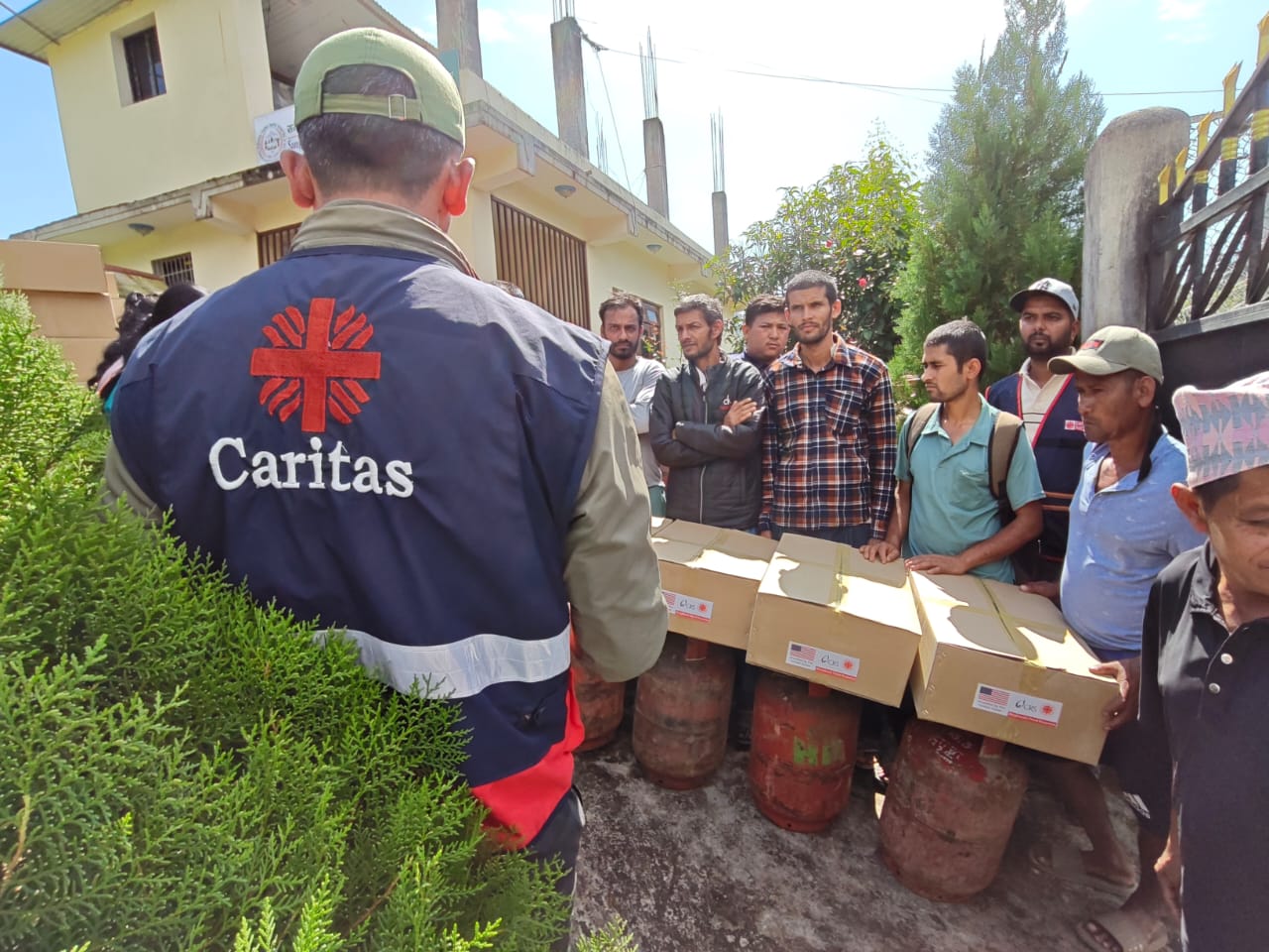 Caritas team distributing kitchen and bedding supplies to families